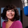 Minou Petrowski posant près d'un micro dans le studio 22 de la Maison de Radio-Canada.