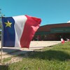 Des drapeaux acadiennes flottent devant le Carrefour Beausoleil