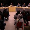Des gens assis devant la table du conseil municipal.