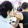 Brian Maci from New York receives a monkeypox vaccine at an outdoor walk-in clinic in Montreal, Saturday, July 23, 2022. Tourists are among those lining up to get monkeypox vaccines in Montreal, as the World Health Organization declares the virus a global health emergency. THE CANADIAN PRESS/Graham Hughes
