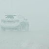 Une auto circule dans la tempête de neige. 
