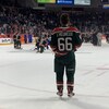 Un joueur de hockey de dos sur une glace. 