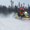 Un motoneigiste se déplace dans de la neige folle. 