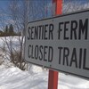 Une affiche « Sentier fermé » vue en hiver.