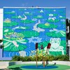 Des fleurs vertes sont peintes sur du bleu sur le mur d'un édifice.