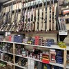 Dans un magasin, des munitions et des armes sont étalées dans des présentoirs.
