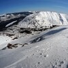 Des pistes de ski au sommet d'une montagne enneigée.