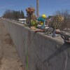 Un muret en béton avec des objets commémorant la mort d'une personne.