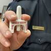 Un inspecteur de police tient un vaporisateur nasal de Narcan devant l'objectif.