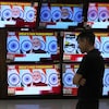 Un homme regarde le premier ministre Narendra Modi sur les écrans de téléviseurs dans un commerce.