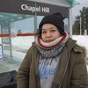 Une femme est devant un arrêt d'autobus à Ottawa.