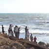 Des Libanais regardent vers la mer près du poste-frontière d'Arida avec la Syrie, le 23 septembre 2022, alors que des proches attendent l'arrivée des corps des personnes qui se sont noyées lors du naufrage d'un bateau au large de la Syrie.
