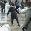 Une Torontoise soulève une botte pour ne pas marcher dans une mare d'eau glacée au centre-ville.