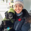 Nicole Chan sourit et tient un chien