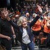 Rachel Notley salue des partisans dans une salle.