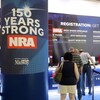 Des gens font la file pour s'enregistrer à l'assemblée. On voit une affiche disant : « La NRA, forte depuis 150 ans. »  