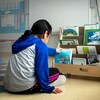 Une jeune fille observe des livres.