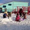 Des enfants construisent un igloo dans la neige devant l'école Nanook, près d'Iqaluit, le 4 novembre 2022.