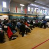 Un groupe de personnes assises dans un gymnase durant des consultations publiques, le 14 novembre 2022, à Iqaluit.