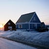 Deux maisons dans une rue enneigée d'Iqaluit, durant l'hiver.