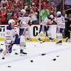 Des joueurs des Oilers, genou par terre sur la glace jonchée de rats en caoutchouc, d'autres debout tout aussi dépités, devant une foule partisane des Panthers debout.