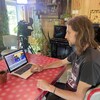 Oli Laroche montre son clip sur un ordinateur. Il est assis dans son appartement.