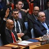 Un homme lève la main droite pendant une réunion.