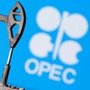 Une maquette de pompe à pétrole devant le logo de l'OPEP, en anglais.