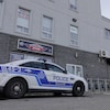 Une voiture de police stationnée devant le commerce « ML Multi-Pièces d'auto ».