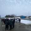 Des gens attendent au bord d'une rue.