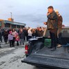 Des personnes à l'extérieur qui regarde quelqu'un donnant un discours.