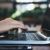 Une main d'homme sur le clavier d'un ordinateur portable.