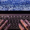 Un homme tape sur un clavier d'ordinateur. 