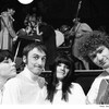 Les quatre artistes posent sur scène avec quelques musiciens en arrière-plan. 