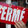 Une enseigne «fermé» dans la porte d'un commerce.