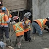Des ouvriers coulent du béton sur un chantier.
