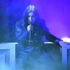 Ozzy Osbourne, sur scène, porte un micro avec une croix.