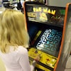 Une femme joue à une version arcade du jeu « Pac-Man ».