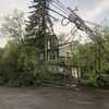 Un poteau électrique et des arbres cassés près d'une maison en été 