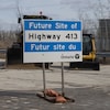 Un panneau qui annonce l'emplacement de la future autoroute 413 devant de l'équipement lourd à Woodbridge, en Ontario.