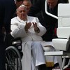 Le pape François assis dans un fauteuil roulant, près de la papemobile.
