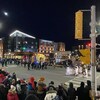 Des gens rassemblés dehors en hiver pour la parade de Noël à Moncton, au Nouveau-Brunswick. 