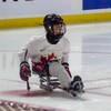 La joueuse de parahockey, Raphaëlle Tousignant, sur la luge au cercle des mises au jeu près du but.