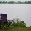 Une chaise de camping devant le fleuve.