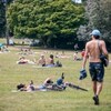 Des gens en tenue légère se prélassent dans un parc. 