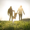 Deux parents et un enfant dans un parc.