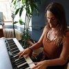Pastelle Leblanc joue du piano dans son salon.