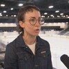 Une femme en entrevue devant une patinoire intérieure.
