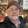 Paul-Émile Doucet sourit et pose pour une photo à l'intérieur du marché public.