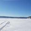 Des cabanes de pêche au loin sur les glaces du Saguenay à Saint-Fulgence.